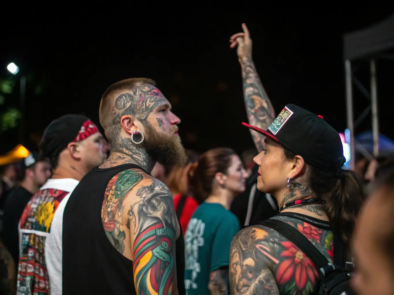 A photograph of a community member admiring a tattoo artwork at a TREW NORMAND exhibition, highlighting the engagement and appreciation of art.